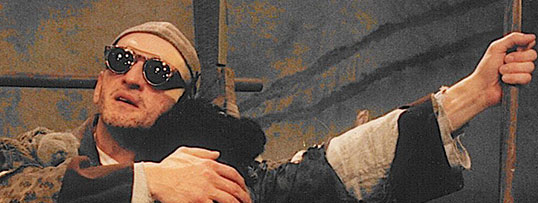 Twarz Krzysztofa Bienia w czarnych okularach, po prawej stronie widać fragment laski/kija