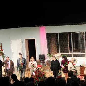 Aktorzy na zakonczenie spektaklu na scenie, na tle scenografii przypominającej wnętrze mieszkania