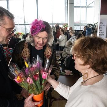 Dyrektor Marek Mokrowiecki i z-ca dyrektora Wojciech Jasiński wręczają kwiaty paniom. W tle zgromadzenie pracowników.