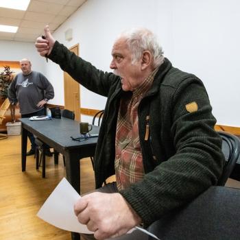 Próba muzyczna do spektaklu, Krzysztof Szuster-reżyser z podniesioną dłonią w geście 